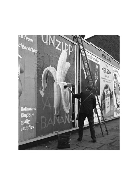 Man pastes up a billboard advertisement. c.1955