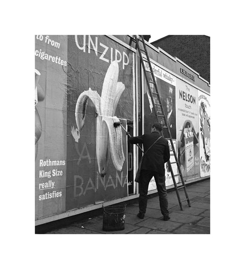 Man pastes up a billboard advertisement. c.1955