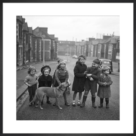 Children gathered in street with dog. c.1955
