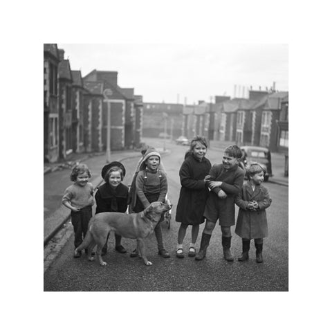 Children gathered in street with dog. c.1955