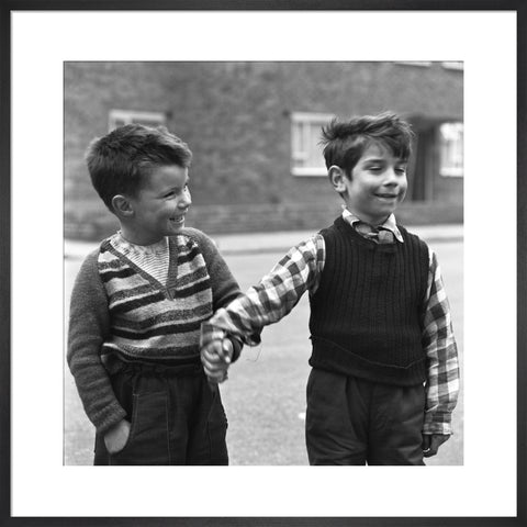 Two boys hold hands in street. c.1955