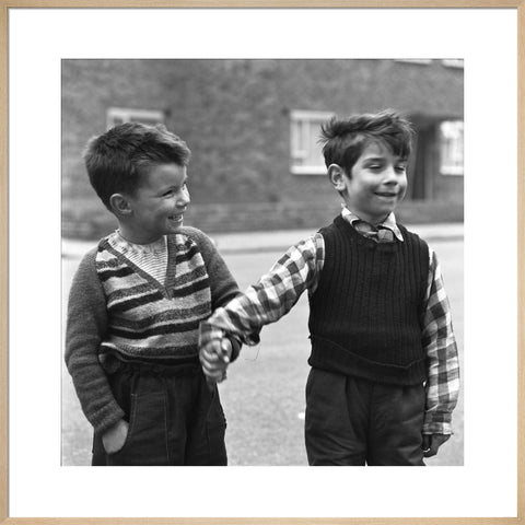 Two boys hold hands in street. c.1955