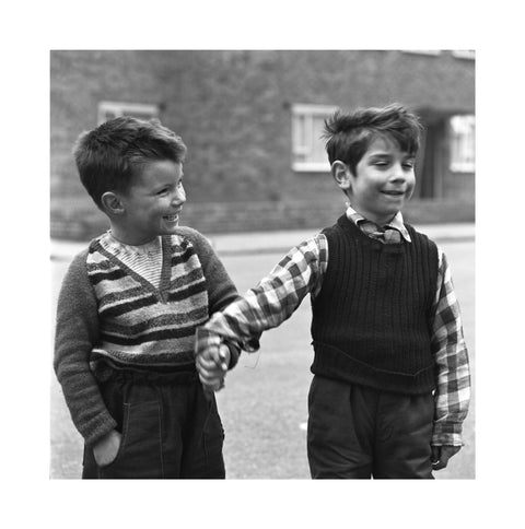 Two boys hold hands in street. c.1955