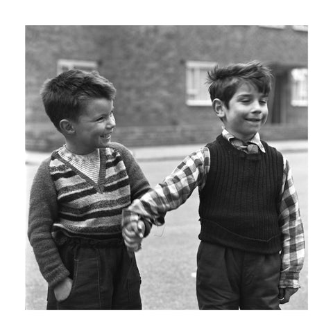 Two boys hold hands in street. c.1955