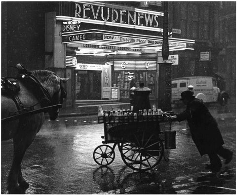 A milkman pushing a cart along Charing Cross Road