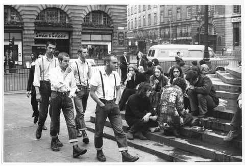 Skinheads pass Hippies in Piccadilly Circus