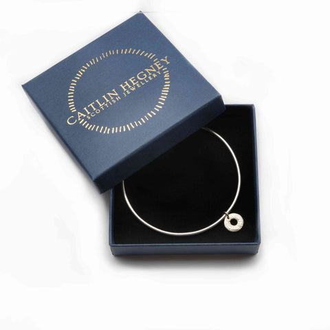 Silver bracelet in a blue box with 'Cailtin Hegney' branding in golden letters