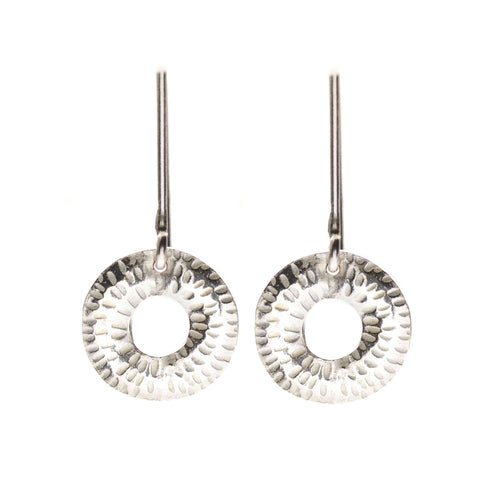 Pair of silver earrings with circular designs on a white background