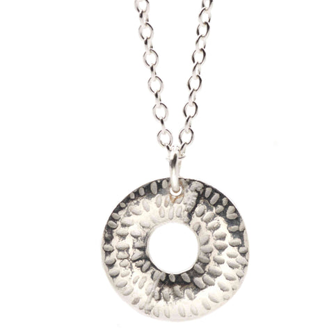 Silver necklace with a textured circular pendant on a white background