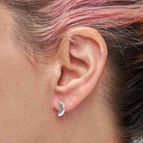 Close-up of a person with pink and brown hair wearing a silver stud earring 