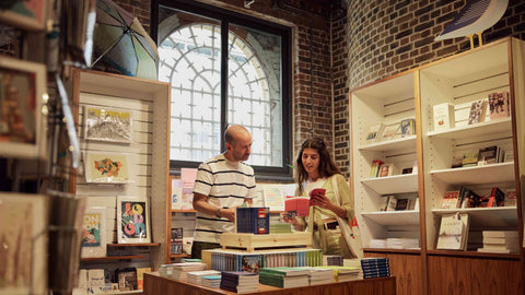 A man and a woman browse books at the London Museum Docklands shop