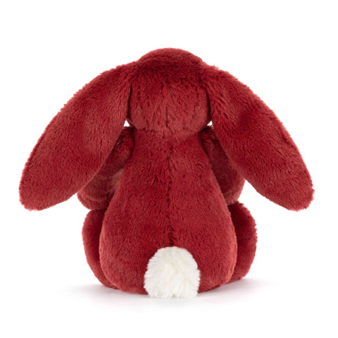 View from the back of a red plush bunny toy on a white background