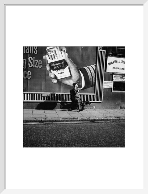 Visually impaired boy walking down street with his guide dog.