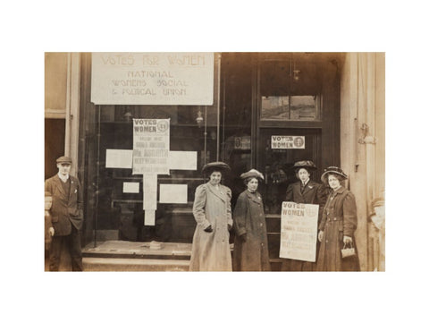 Photographic postcard of leading Suffragettes standing outside a branch shop of the Women's Social and Political Union in Hawick Scotland.