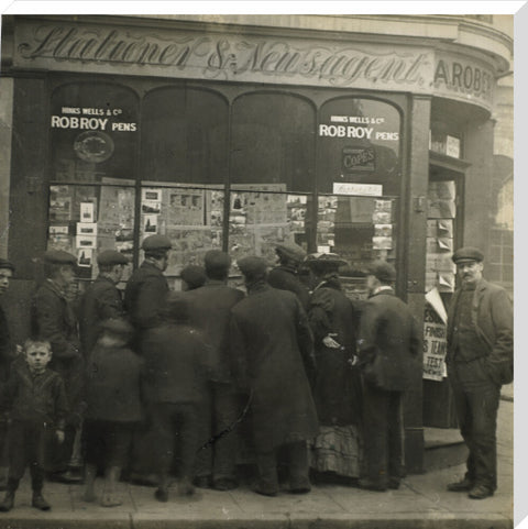 A crowd gathered around an East End newsagents window display c.1900