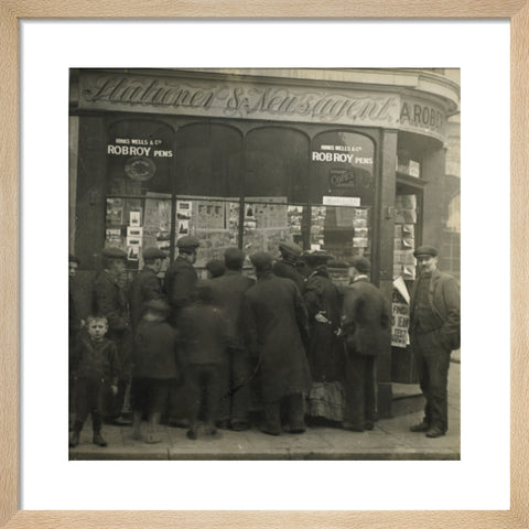 A crowd gathered around an East End newsagents window display c.1900