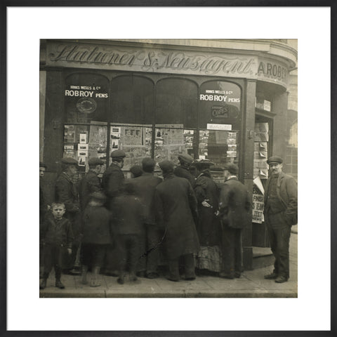 A crowd gathered around an East End newsagents window display c.1900