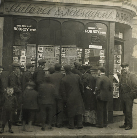 A crowd gathered around an East End newsagents window display c.1900