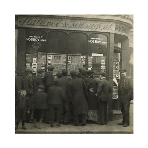 A crowd gathered around an East End newsagents window display c.1900