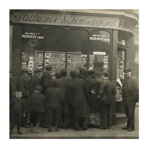 A crowd gathered around an East End newsagents window display c.1900