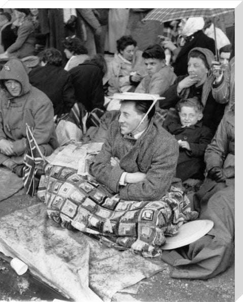 Spectators waiting on the pavement for Queen Elizabeth II's Coronation 1953