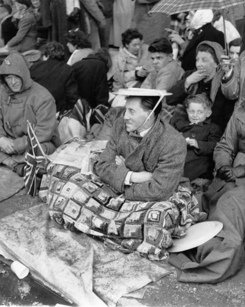 Spectators waiting on the pavement for Queen Elizabeth II's Coronation 1953