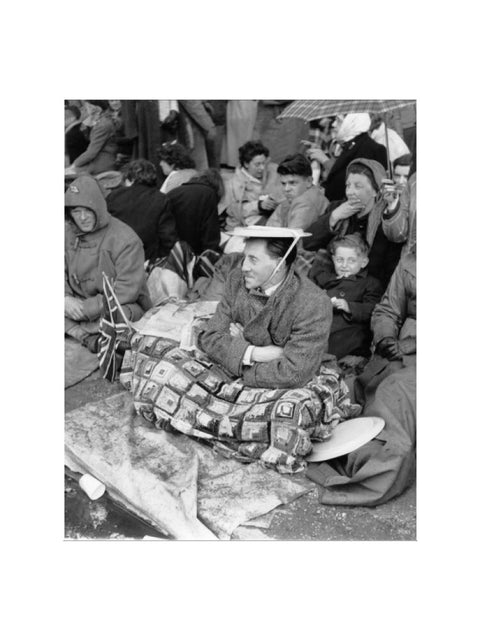 Spectators waiting on the pavement for Queen Elizabeth II's Coronation 1953