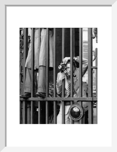 A photographer takes a picture through the railings at Admiralty Arch 1953