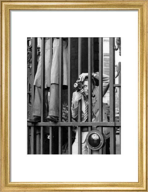 A photographer takes a picture through the railings at Admiralty Arch 1953