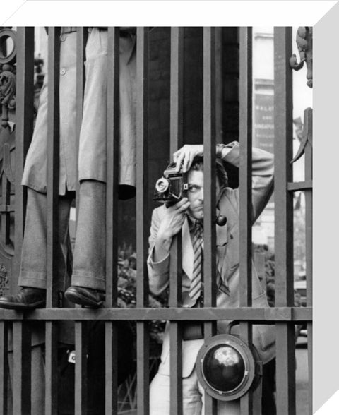 A photographer takes a picture through the railings at Admiralty Arch 1953