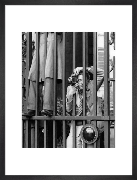 A photographer takes a picture through the railings at Admiralty Arch 1953