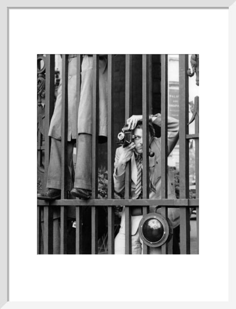 A photographer takes a picture through the railings at Admiralty Arch 1953