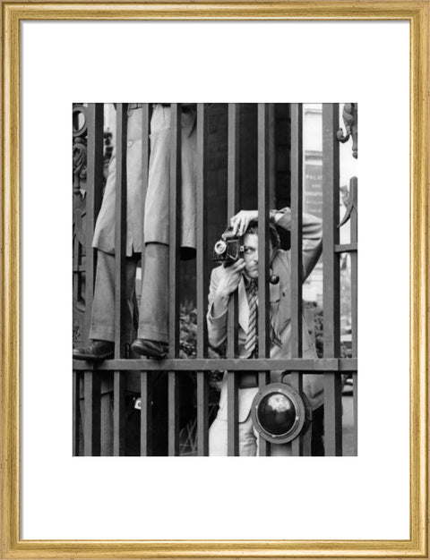 A photographer takes a picture through the railings at Admiralty Arch 1953