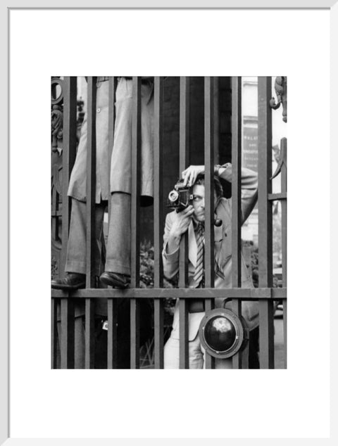 A photographer takes a picture through the railings at Admiralty Arch 1953