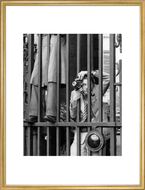 A photographer takes a picture through the railings at Admiralty Arch 1953