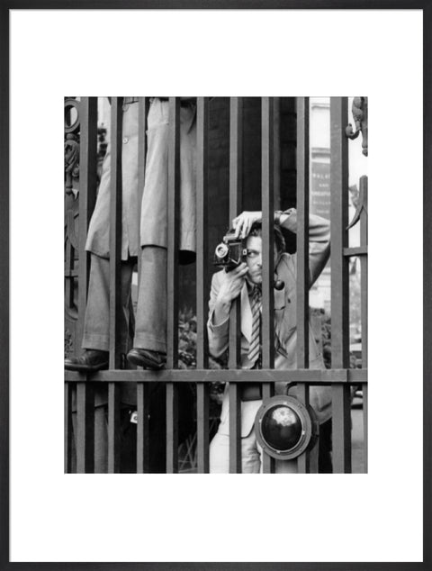 A photographer takes a picture through the railings at Admiralty Arch 1953