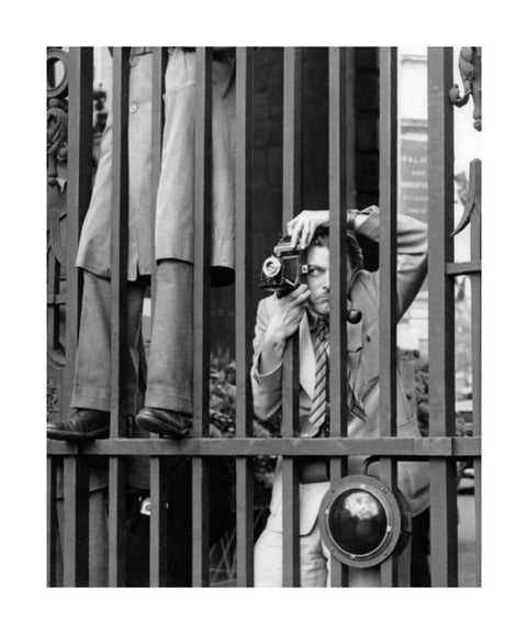 A photographer takes a picture through the railings at Admiralty Arch 1953