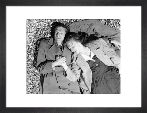 A couple lying together on Brighton Beach c. 1955