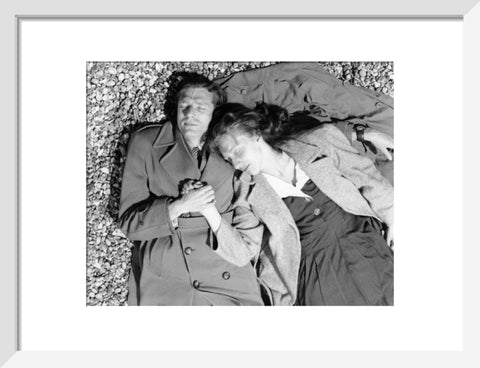 A couple lying together on Brighton Beach c. 1955