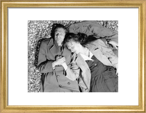 A couple lying together on Brighton Beach c. 1955