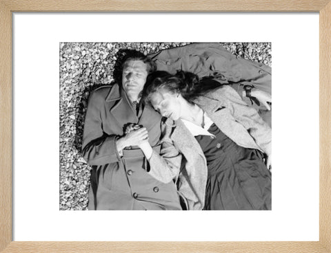 A couple lying together on Brighton Beach c. 1955