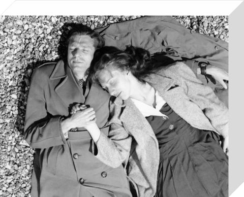 A couple lying together on Brighton Beach c. 1955