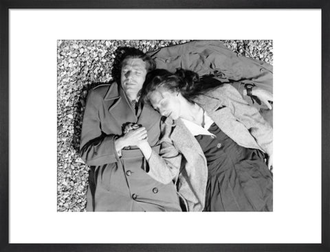 A couple lying together on Brighton Beach c. 1955