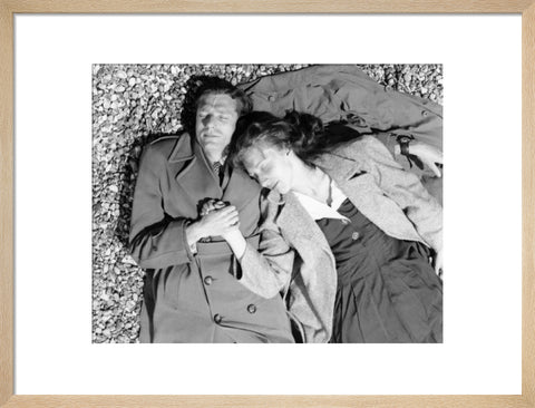 A couple lying together on Brighton Beach c. 1955