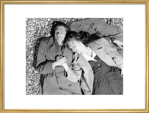 A couple lying together on Brighton Beach c. 1955