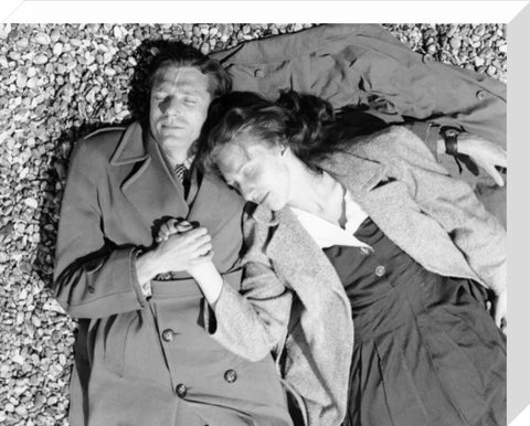 A couple lying together on Brighton Beach c. 1955