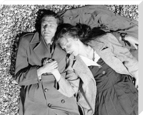 A couple lying together on Brighton Beach c. 1955