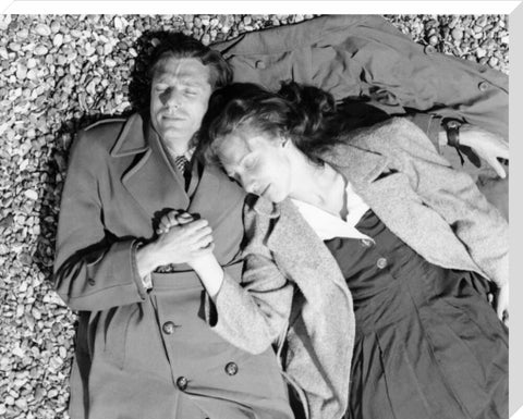 A couple lying together on Brighton Beach c. 1955