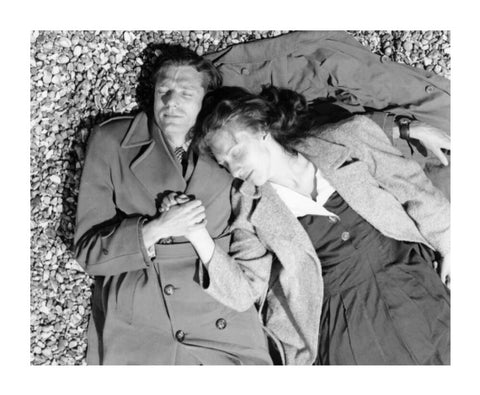 A couple lying together on Brighton Beach c. 1955