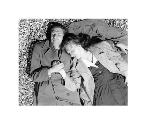 A couple lying together on Brighton Beach c. 1955